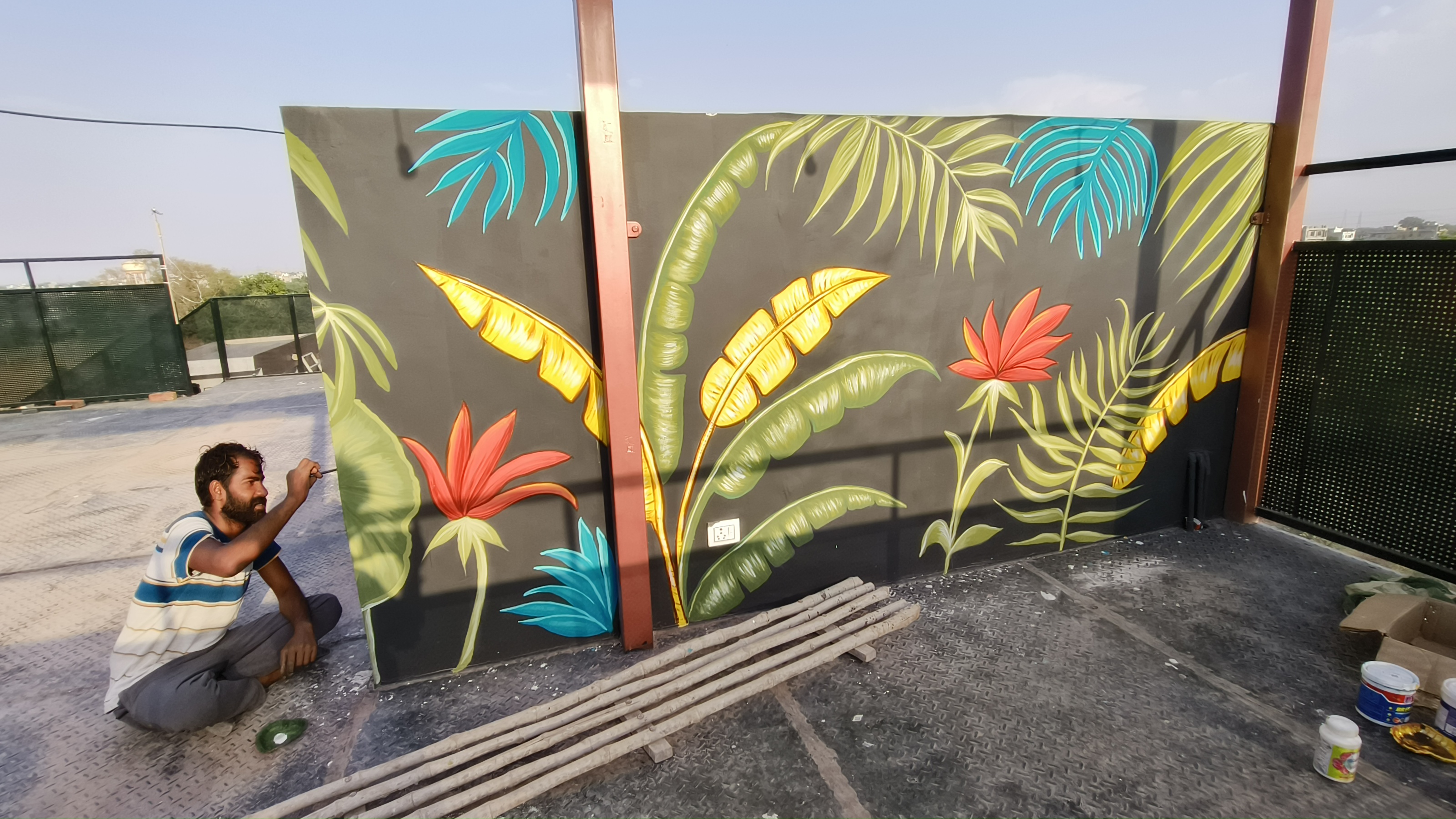 Wall painting artist Mahesh Kumawat creating a large custom wall mural at a client location